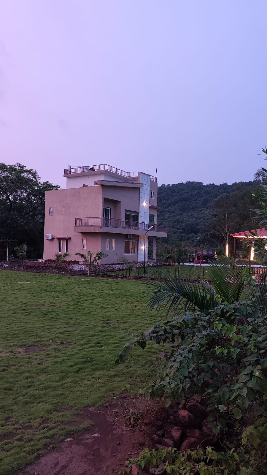 The villa at dusk, with the lawn in the foreground.