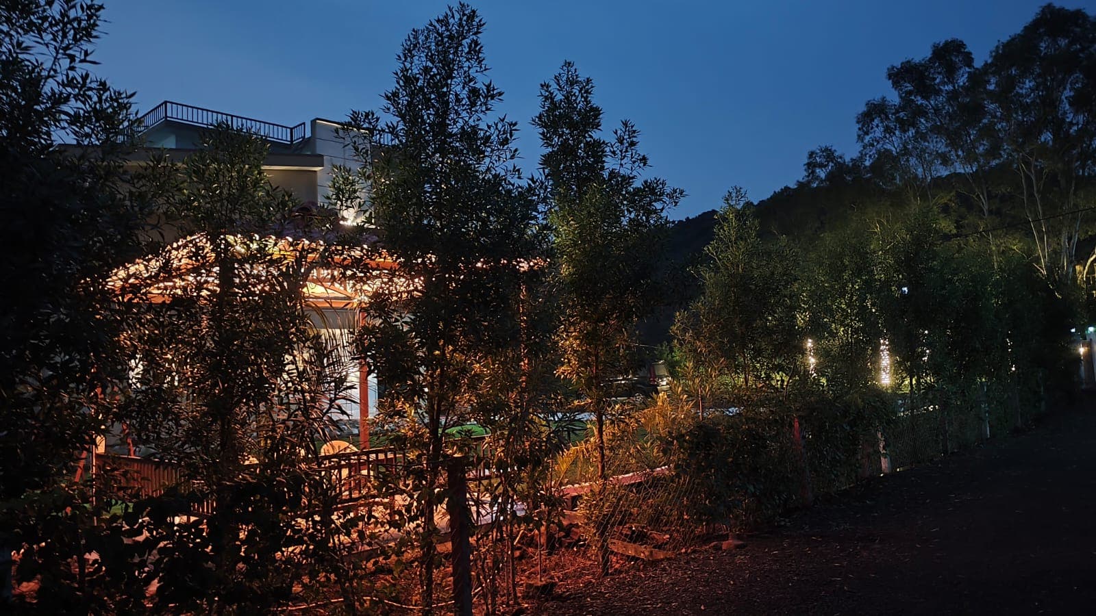 The gazebo lit after dark, with the hill behind it.