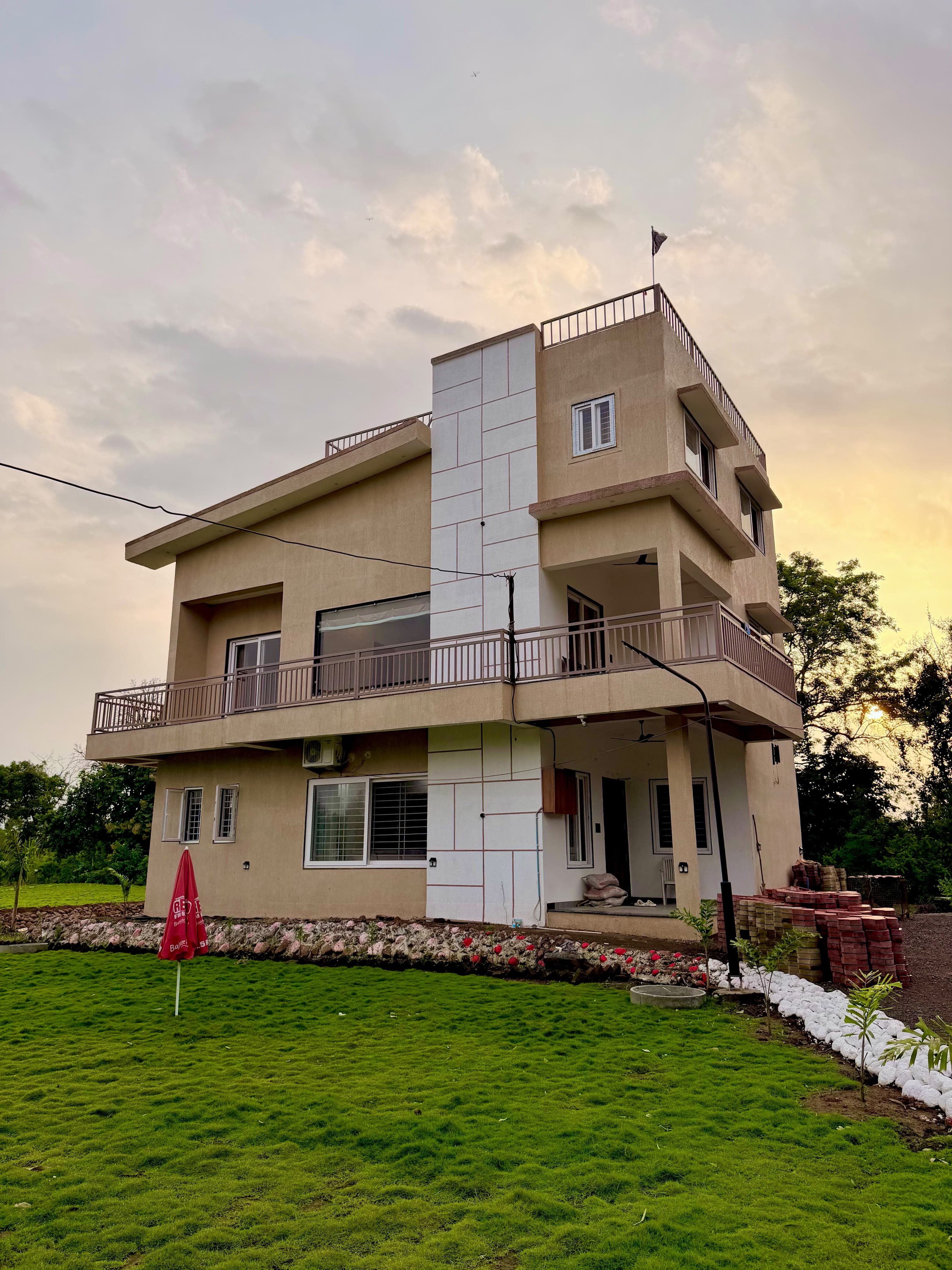The Saanjh villa and front lawn in warm evening light.