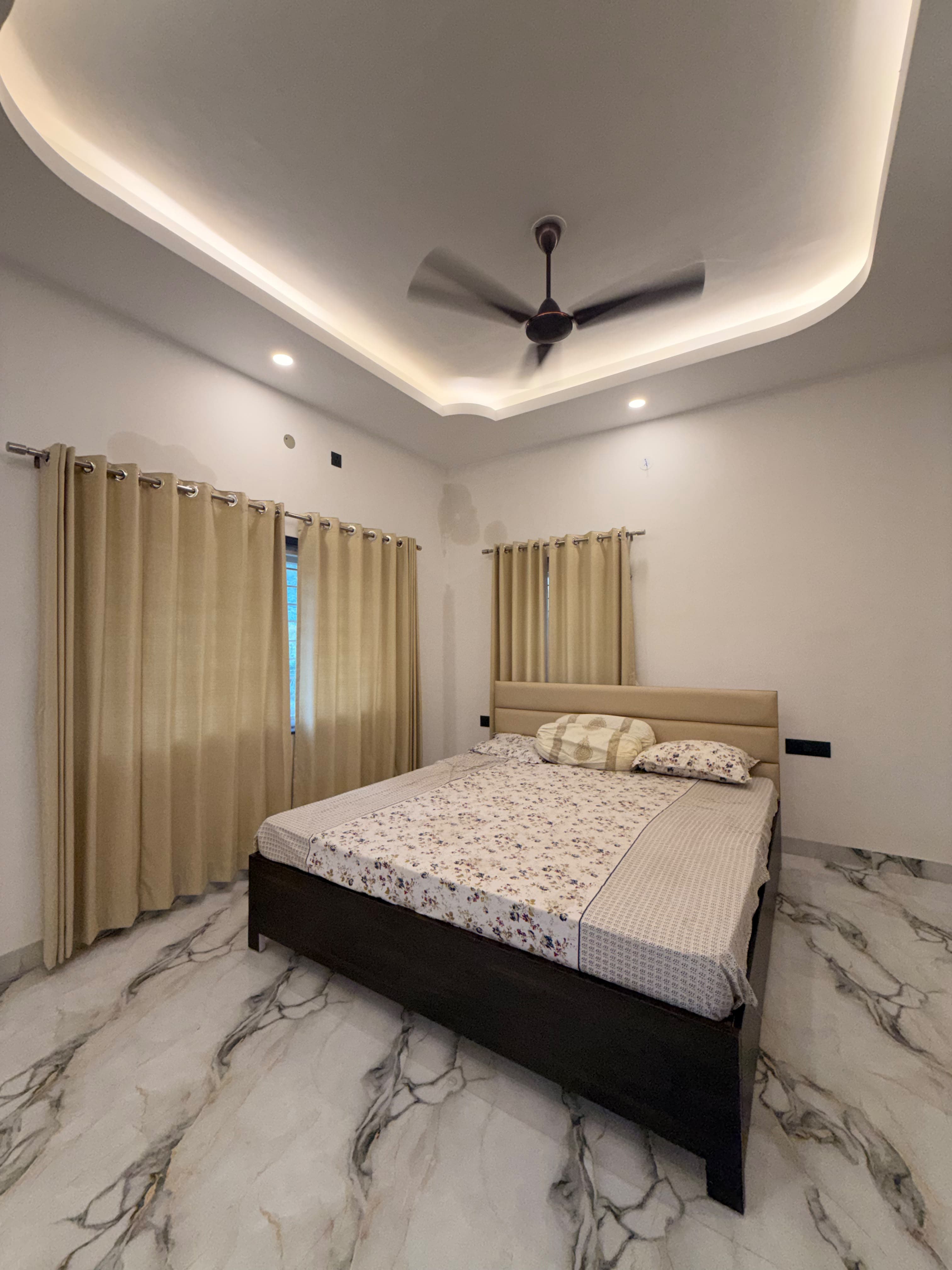 Reva, a quiet second-floor bedroom with floral bedding and stone underfoot.