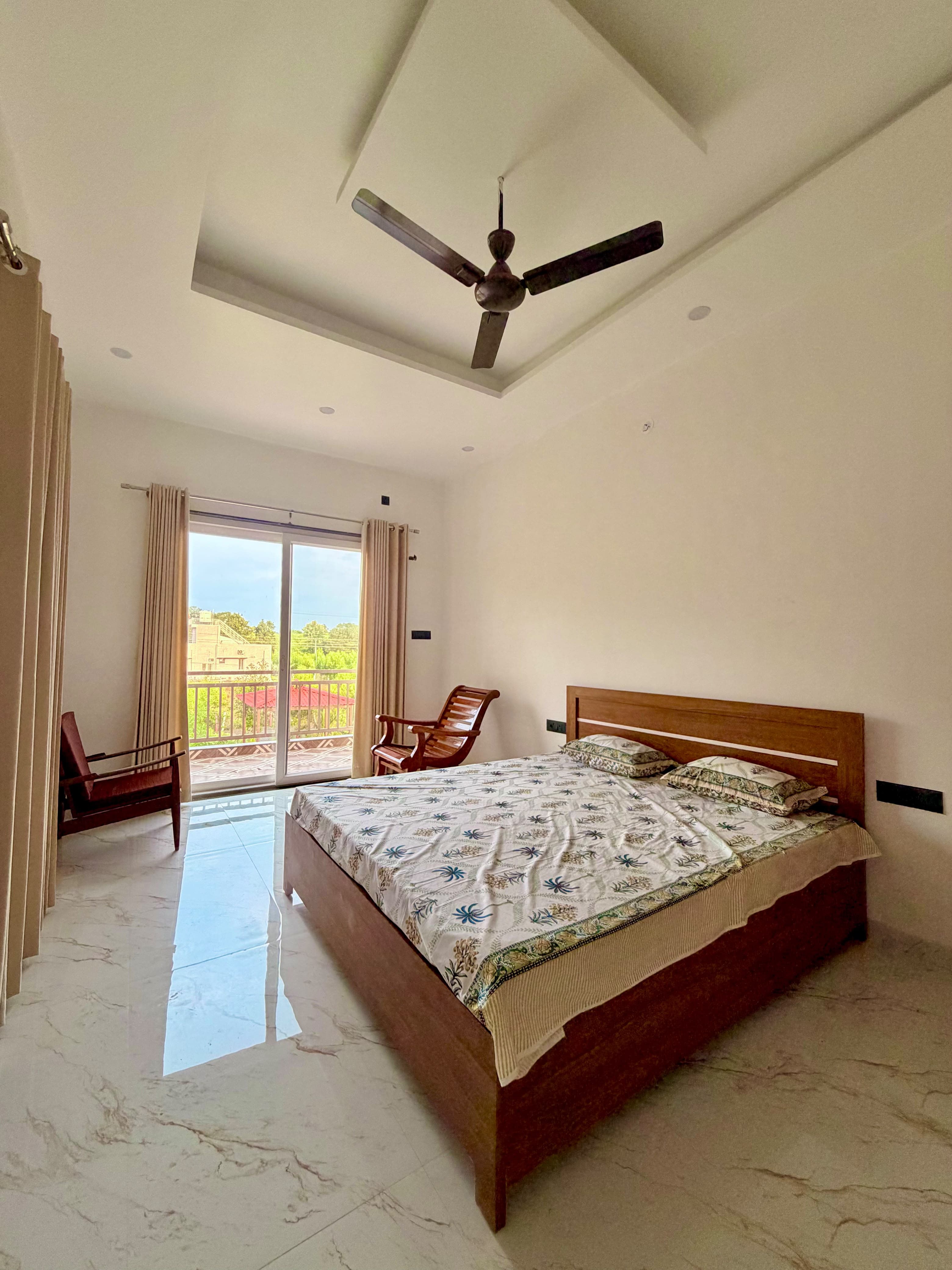 Room Two, with a wooden bed and a door to the balcony.